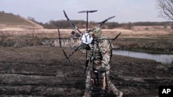 A Russian soldier carries a captured Ukrainian drone. Russia reports the destruction of Ukrainian drones almost daily, but the attacks rarely target the capital. (file photo)