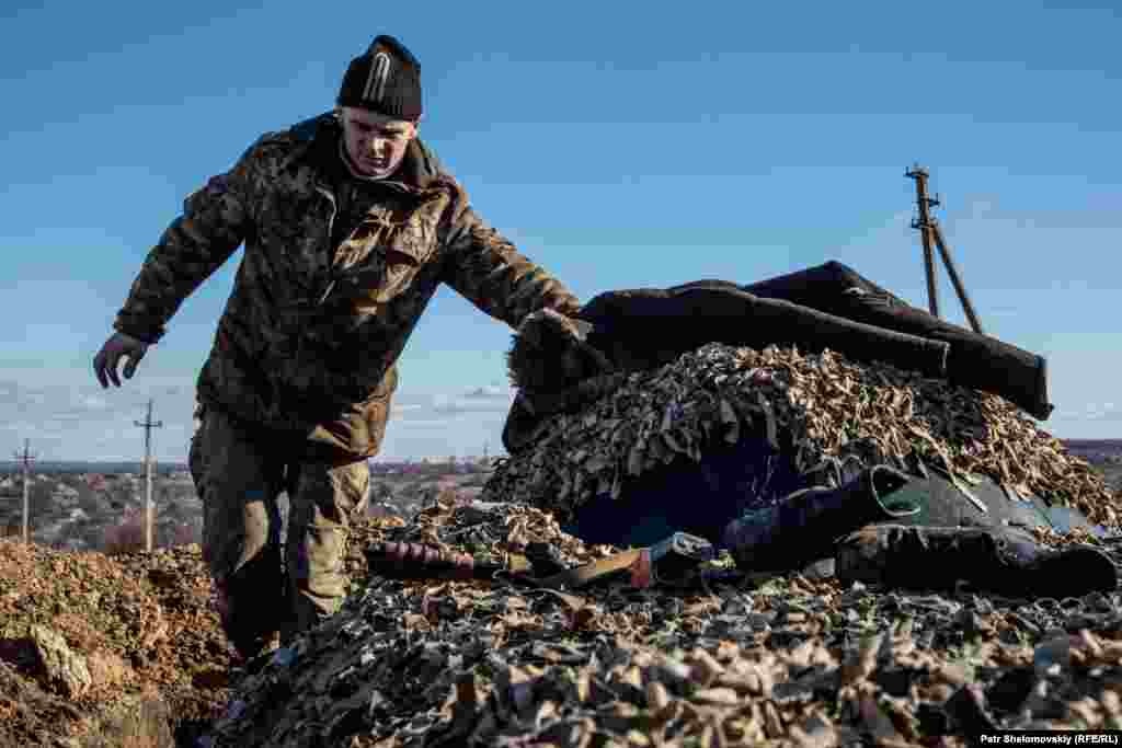 A Ukrainian government serviceman walks on top of an armored vehicle near Zaytseve.