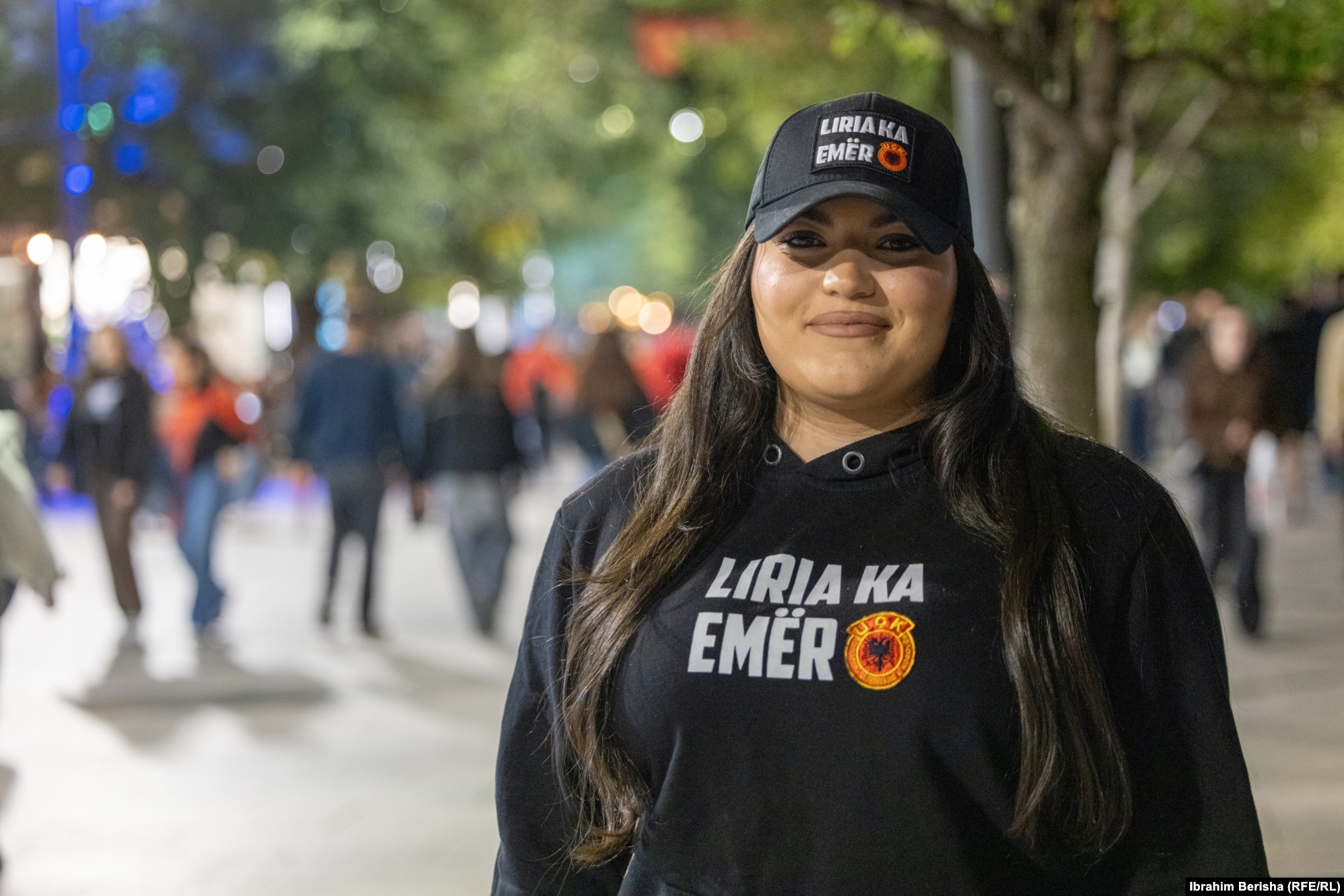 Lediona Sadria para nisjes së protestës. Sikurse Lediona, edhe shumë pjesëmarrës të tjerë në protestë kanë të veshura bluza me mbishkrime "Liria ka emër", apo me mesazhe të tjera në mbështetje të UÇK-së.