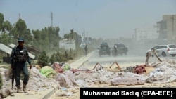 Afghan security officials inspect the scene of a bomb explosion in Kandahar on May 22.