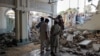 People gather at a damaged mosque following a suicide attack at a police facility in the Pakistani city of Kohat on September 18. 