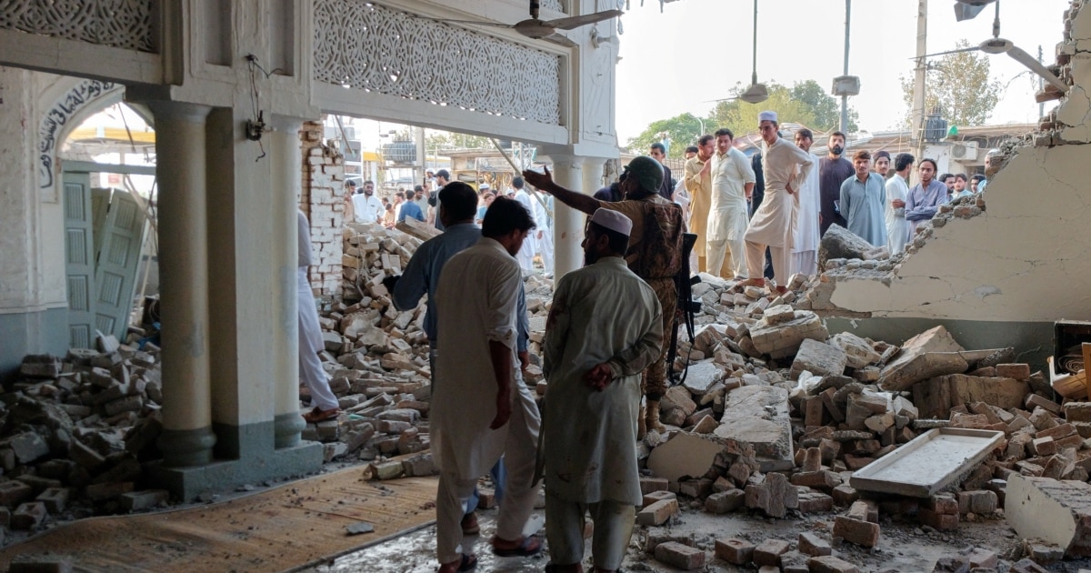 People gather at a damaged mosque following a suicide attack at a police facility in the Pakistani city of Kohat on September 18.