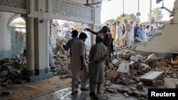 People gather at a damaged mosque following a suicide attack at a police facility in the Pakistani city of Kohat on September 18. 