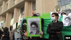 Opposition supporters hold placards with images depicting the late supreme leader of the 1979 Islamic Revolution Grand Ayatollah Ruhollah Khomeini as they stage a demonstration at the Tehran University