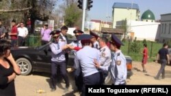 Полицейлер қарсылық білдірген әйелді әкетіп барады. Алматы, 2 мамыр 2011 жыл.