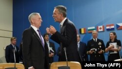 U.S. Secretary of Defense Jim Mattis (L) talks with NATO Secretary-General Jens Stoltenberg (R) during a defense minister meeting at the Nato headquarters in Brussels on November 7