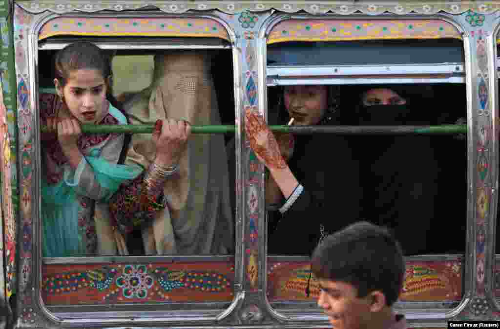 Women riding in a van react to something happening outside in Rawalpindi, Pakistan, on October 5. (Reuters/Caren Firouz)