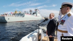 Președintele rus Vladimir Putin și comandantul șef al marinei ruse, amiralul Alexander Moiseiev, la parada anuală de Ziua Marinei din Sankt Petersburg, Rusia, 28 iulie 2024. 