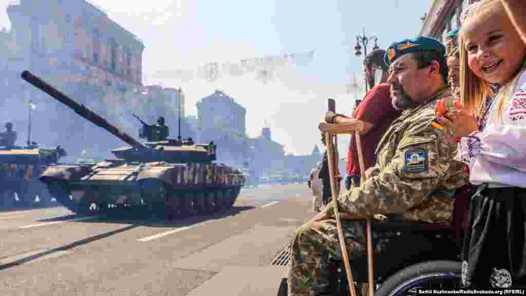A soldier and a young girl watch the Independence Day march in Kyiv, Ukraine, which marked 30 years of statehood on August 24, 2021.&nbsp;