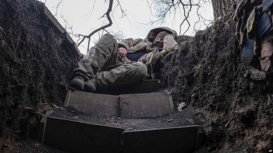 Un soldat ucrainean se odihnește într-un șanț de pe linia frontului lângă Liman, în regiunea Donețk, pe 29 martie.