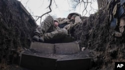 A Ukrainian soldier takes a rest in a trench on the front line near Lyman, in the Donetsk region, on March 29.