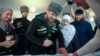 Aymani Kadyrova (center right) stands next to her son, Chechen strongman Ramzan Kadyrov, as he registers at a polling station in the Chechen town of Tzentoroi, Russia, in 2016. 