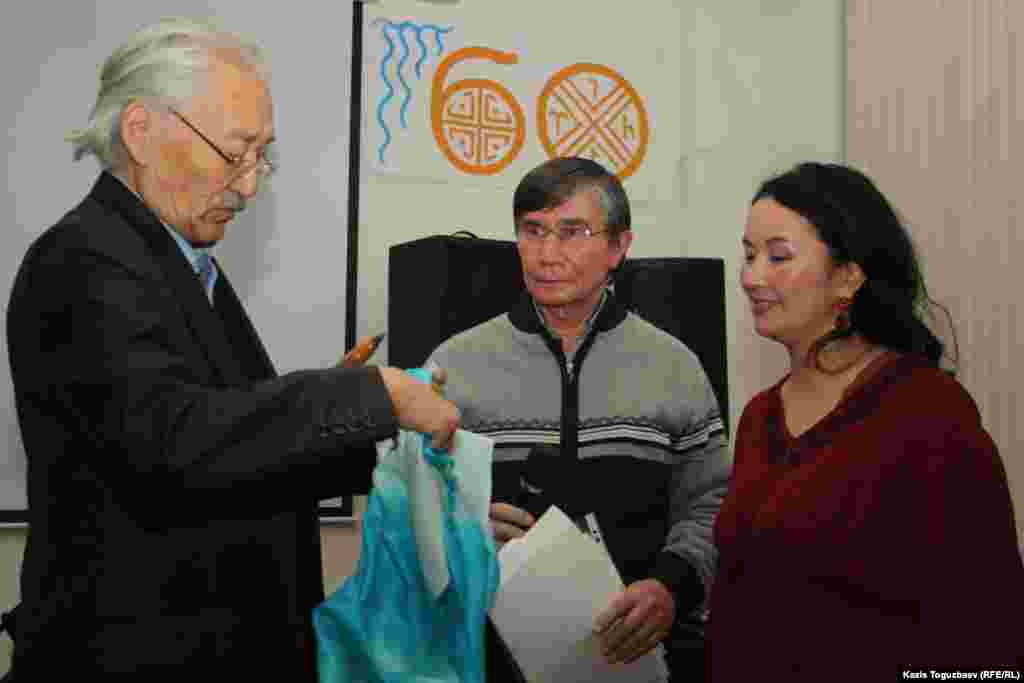Писатель Габбас Кабышулы подарил шарф Жайне Айдархан в знак того, что Арон Атабек выйдет на свободу и в его семье будет праздник. 