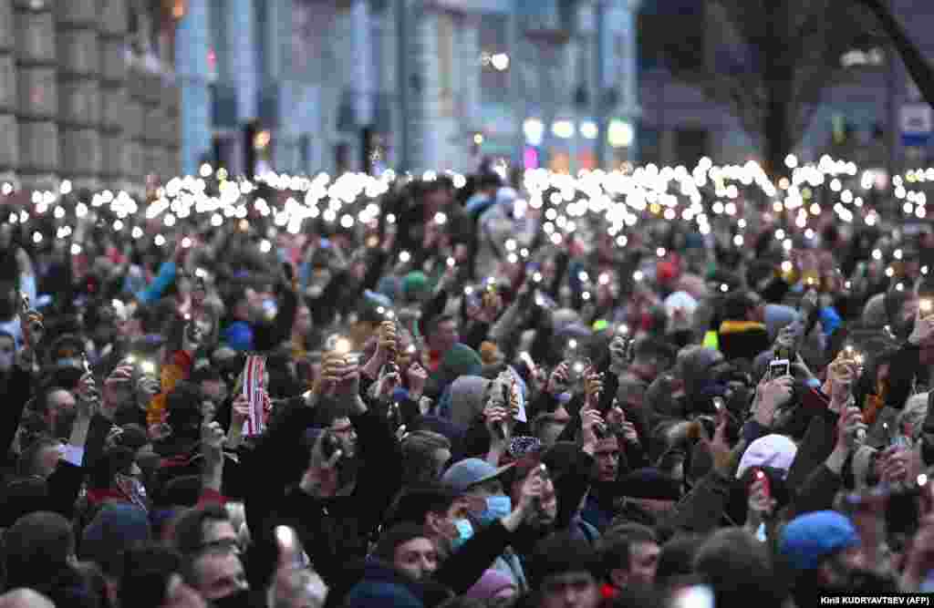 Protesters hold up their phones in Moscow.