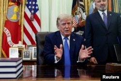 U.S. President Donald Trump signs executive orders at the Oval Office in Washington on August 6.