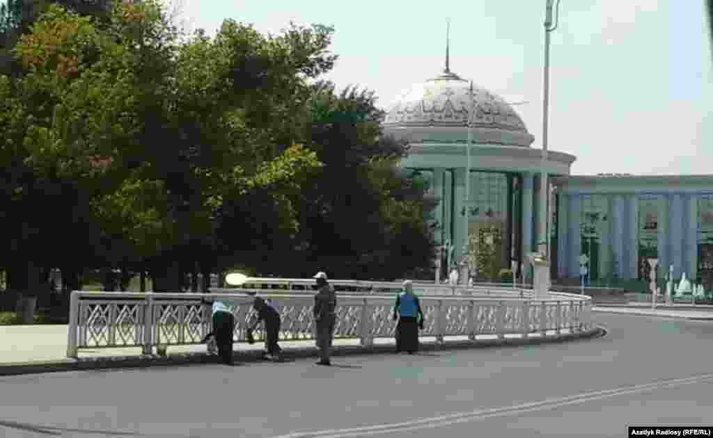 Türkmenistanyň Gurluşyk we binagärlik ministrliginiň Jemagat hojalygy müdirliginiň işgärleri köçeleriň gyralaryndaky demir haýatlary reňkleýärler.