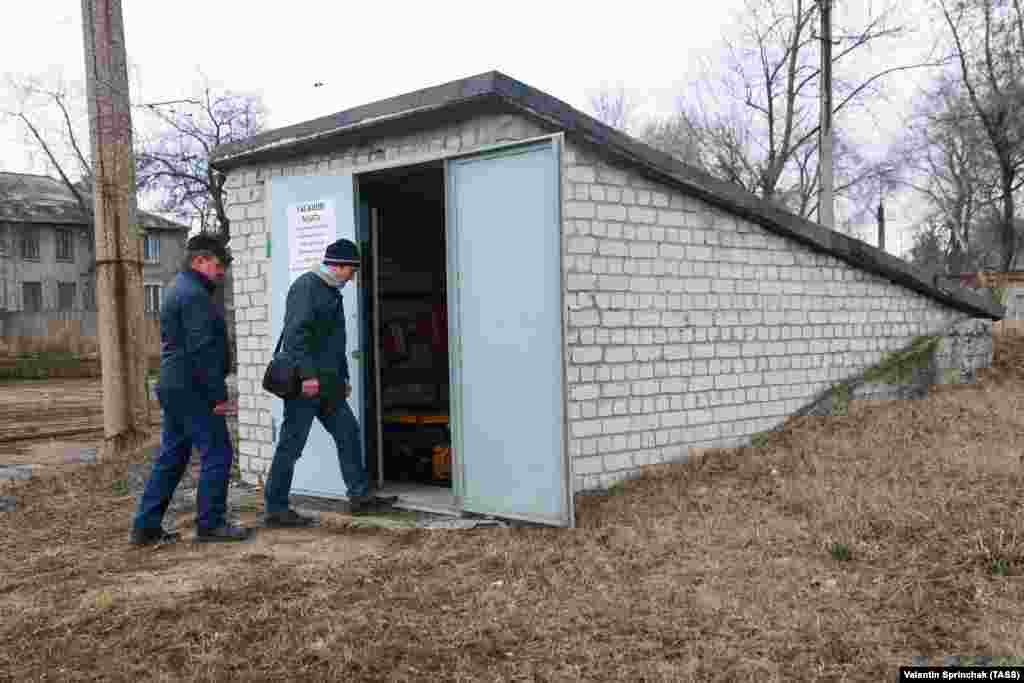 Мужчины заходят в бомбоубежище на территории трамвайного депо в Донецкой области. 24 марта 2021 года. Эта зона контролируется сепаратистами.