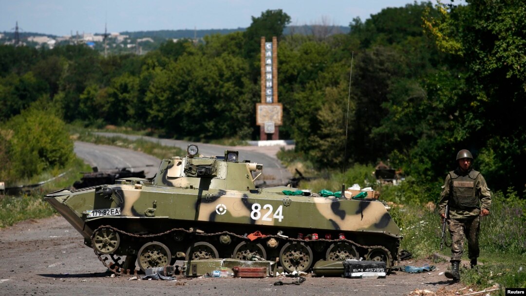 A Ukrainian soldier walks near a destroyed armored vehicle outside Slovyansk in eastern Ukraine on July 5. 