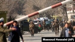 Сотрудники сил безопасности на месте атаки в центре Кабула. 27 января 2018 года.