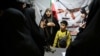 A military officer teaches women and children how to use a gun at a booth on Hafte-Tir Square, in Tehran, Iran, May 18.