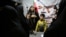 A military officer teaches women and children how to use a gun at a booth on Hafte-Tir Square, in Tehran, Iran, May 18.
