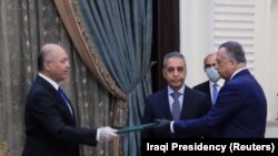 Iraqi President Barham Salih hands power to newly appointed Prime Minister Mustafa al-Kadhimi in Baghdad, April 9, 2020