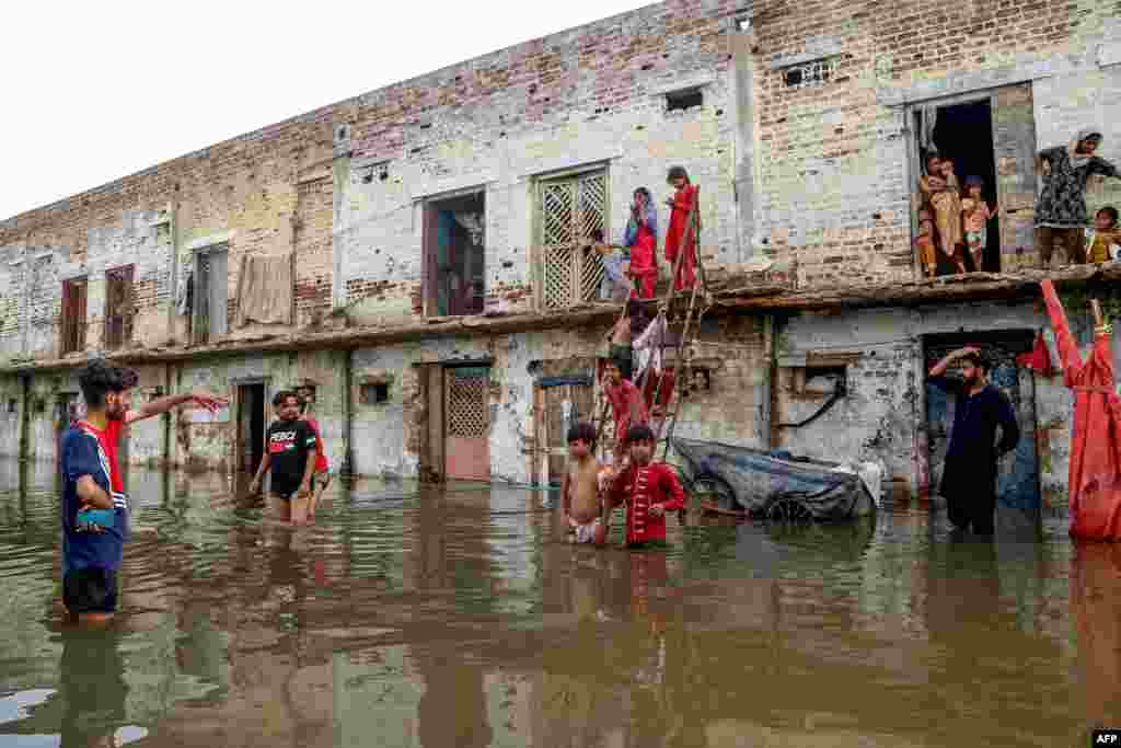 Residents gather outside their houses after they were submerged by floodwaters following heavy monsoon rains in Hyderabad in Pakistan's Sindh Province.