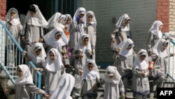 File photo:Iranian girls head home after classes end at Sizdah Abban school in north of Tehran 01 October 2006. (Photo by ATTA KENARE / AFP)