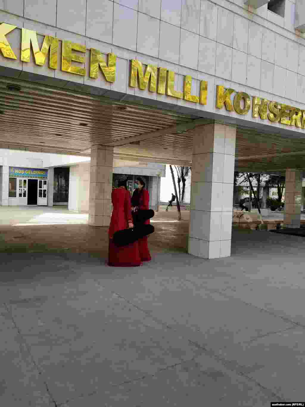 Türkmen milli konserwatoriýasynyň öňünde duran sazanda gyzlar. Aşgabat, aprel, 2021.