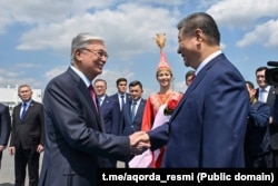 Қазақстан президенті Қасым-Жомарт Тоқаев (сол жақта) елге сапармен келген Қытай президенті Си Цзиньпинді әуежайда қарсы алып тұр. Астана, 16 маусым, 2025 жыл.
