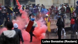 Protestatarii se ciocnesc cu ofițerii de poliție în timpul unui protest împotriva sărăciei și violenței poliției în Bogota, Columbia, 5 mai 2021