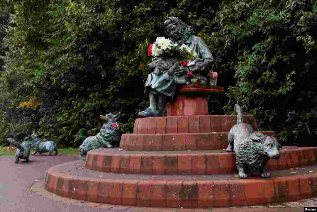 Buchete de flori așezate pe o statuie a reginei Elisabeta și a corgisului ei, numită &bdquo;The Windsor Lady&rdquo;, după moartea monarhului britanic în Windsor, Marea Britanie, 14 septembrie 2022. &nbsp; Regina Elisabeta a II-a era cunoscută pentru dragostea sa pentru câini, iar la momentul morții sale, săptămâna trecută, avea cel puțin patru - doi corgi, un cocker spaniel și un dorgi - un câine născut din teckel și corgi.