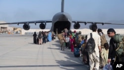 Oameni din Afganistan, evacuați cu un avion al Forțelor aeriene americane, în august 2021.