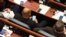 Пратеници во Собранието на пауза меѓу седниците, гледаат во своите мобилни телефони или решаваат крстозбори
