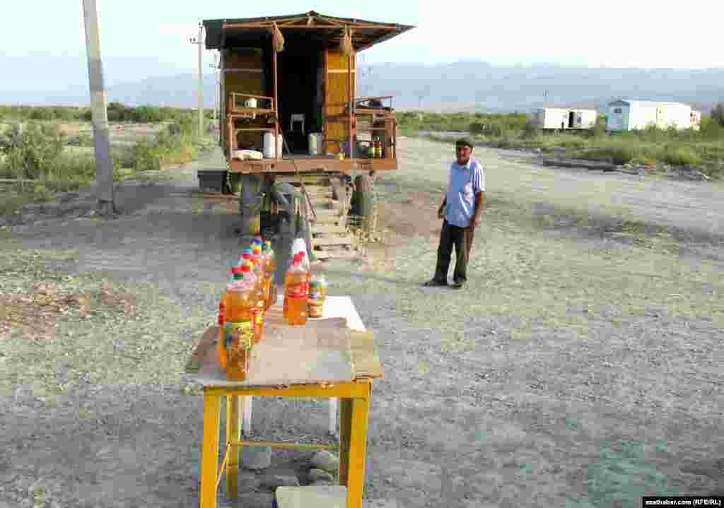 Baharly etrabynyň çäginde ýol ugrunda bal satýan daýhan.