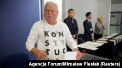 Поранешниот полски претседател Лех Валеска гласа на изборите на 21 октомври, носејќи маица на која пишува Устав