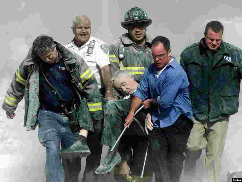 Rescue workers carry fatally injured New York City Fire Department Chaplain, Father Mychal Judge, from one of the World Trade Center towers in New York City, early September 11, 2001. Both towers were hit by planes crashing into the buildings and collapsed a short time later. REUTERS/Shannon Stapleton 