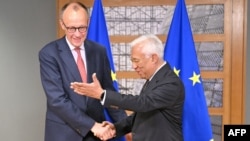 Președintele Consiliului European, Antonio Costa (d) întâmpinându-l pe probabilul viitor cancelar al Germaniei, Friedrich Merz.