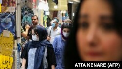 Iran -- Iranians, some wearing protective gear amid the COVID-19 pandemic, shop at the Tajrish Bazaar market in the capital Tehran on July 14, 2020. (Photo by ATTA KENARE / AFP)