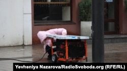 Працівниця кафе в центрі Дніпра налагоджує генератор, від якого заживлений заклад