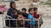 A displaced Iraqi woman and children are seen evacuating as a battle raged between Iraqi forces and Islamic State militants in western Mosul in April 2017.