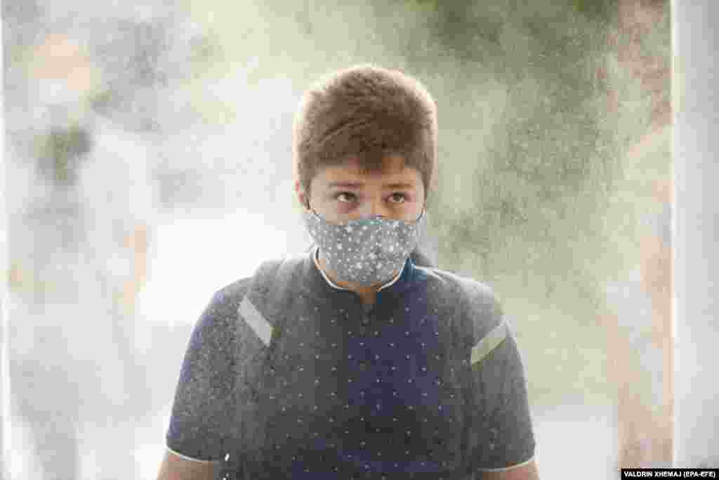 An elementary-school student wearing a face mask passes through a disinfection tunnel on the first day of school in Pristina.&nbsp;​Kosovo&#39;s government postponed the start of the school year for two weeks due to the COVID-19 pandemic.&nbsp;