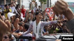 Myanmar's pro-democracy leader Aung San Suu Kyi greets migrant workers from Myanmar in Thailand.