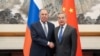 Russian Foreign Minister Sergei Lavrov and his Chinese counterpart Wang Yi shake hands during a meeting in Beijing on April 14.