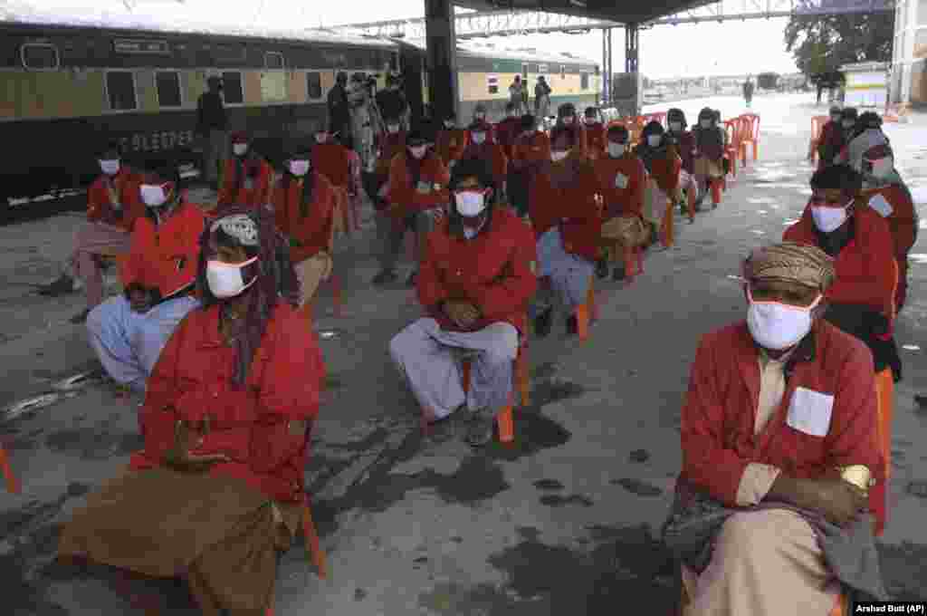 Workers wait to receive relief money as authorities suspended nationwide railway service as a preventive measure against the outbreak of the coronavirus in Quetta, Pakistan. (AP/Arshad Butt)