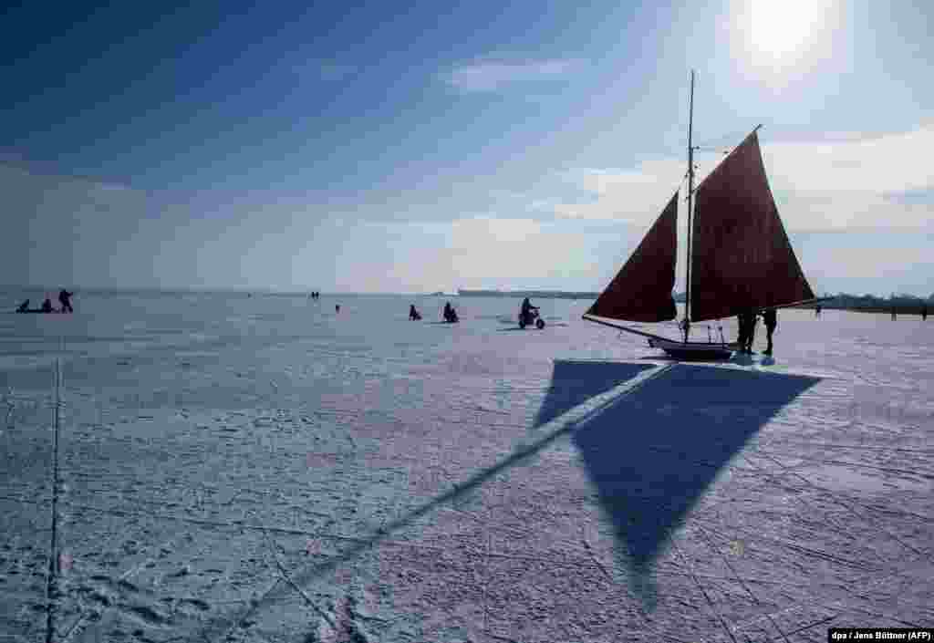 People use traditional iceboats on a frozen lagoon near Ahrenshoop in northern Germany. (AFP/dpa/Jens Buttner)