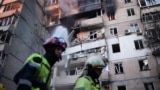 Firefighters work at a heavily damaged residential building following Russian drone and missile strikes in Kyiv on September 7. 