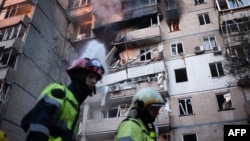 Firefighters work at a heavily damaged residential building following Russian drone and missile strikes in Kyiv on September 7. 