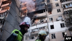 Пожарникари работат на тешко оштетена станбена зграда по руските напади со беспилотни летала и ракети во Киев на 7 септември.