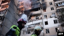 Firefighters work at a heavily damaged residential building following Russian drone and missile strikes in Kyiv on September 7.